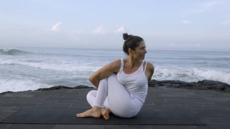 Mature-Woman-Doing-Yoga-near-Ocean