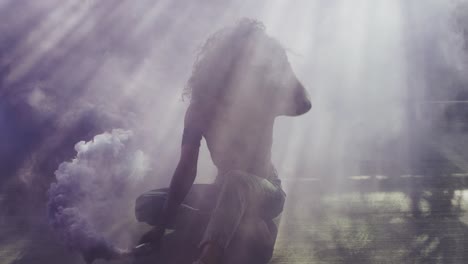 Beautiful-young-woman-modeling-with-purple-smoke-grenade-in-dramatic-moody-lighting