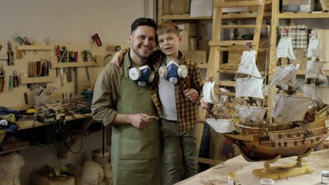 Proud-Father-and-Son-Posing-in-Carpentry-Workshop