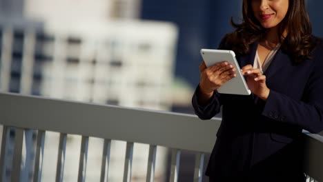 Portrait-of-Hispanic-businesswoman-using-touchscreen-on-rooftop