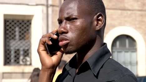 grave-joven-afroamericano-hablando-por-teléfono-en-el-street