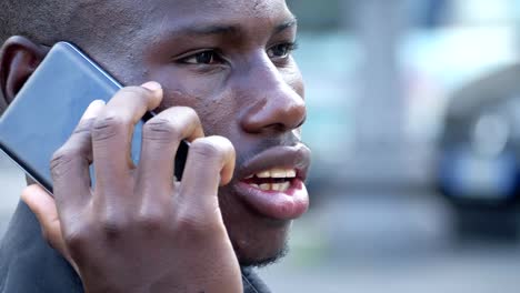 Young-attractive-young-black-african-man-talking-by-phone-in-the-city