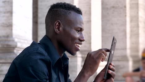 Tecnología,-juventud,-hombre-africano-de-dispositivos-negro-sonriendo-uso-tableta-digital-al-aire-libre