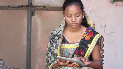 Young-girl-working-on-a-touch-screen-tablet-pad-at-home-in-a-rural-environment-working-learning-studying-communication-network-wireless-confident-thinking-smiling-positive-looking-at-camera-tilt-pan