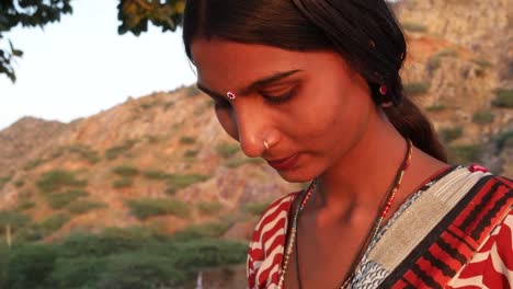 Handheld-shot-of-young-woman-talks-calls-mobile-phone-communication-device-connectivity-signal-wireless-smiles-happy-at-sunset-on-a-hill-outdoor-nature-hot-summer-day-magic-hour-beautiful-serene-love