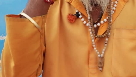 Tilt-up-to-Hindu-holy-man-busy-on-his-mobile-phone-device-Sadhu-baba,-in-Rajasthani