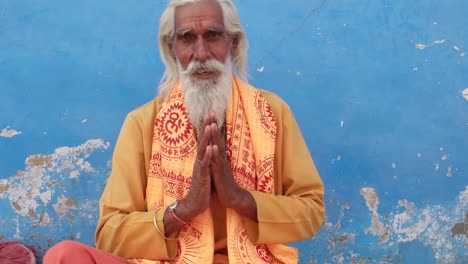 Hindu-Sadhu,-Heiliger-Mann,-Lächeln-auf-den-Lippen-und-Hände-im-Gebet-Mudra-namaste