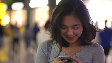 young-woman-using-mobile-phone-in-the-street-,4k