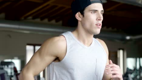 A-shirtless-guy-at-the-gym,-trains-his-body-to-stay-fit-and-have-defined-muscles.-The-athlete-raises-heavy-weights-and-fatigue.