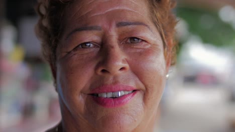 Close-up-Portrait-einer-älteren-hispanische-Frau-mit-einem-silbernen-Zahn-lächelnd-in-die-Kamera