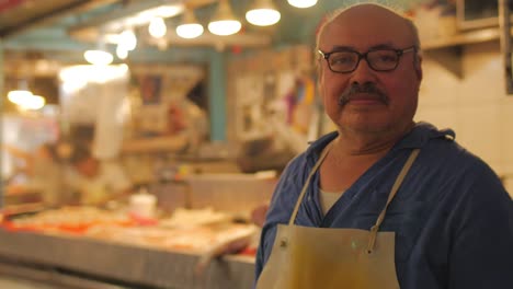 Ein-spanischer-Mann-mit-einem-Schnurrbart-Metzger-Stand-vor-einem-Fischmarkt