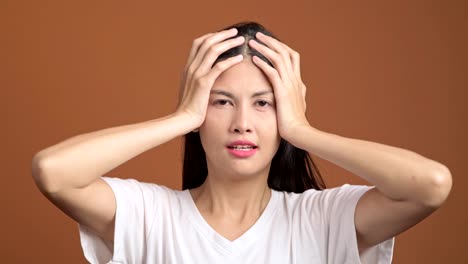 Böse-Frau-isoliert.-Porträt-von-asiatische-Frau-in-weißem-T-shirt-schreien-laut-Blick-auf-Kamera-und-Hand-auf-Kopf.