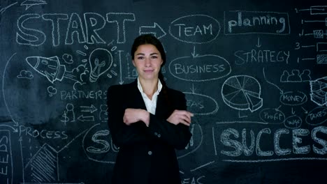 Beautiful-business-girl,-marketing-teacher,-draws-a-graph-of-success-on-a-black-board,-on-a-black-background.