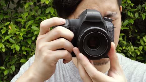 Close-up-of-young-male-photographer-taking-photos-in-nature-scenery