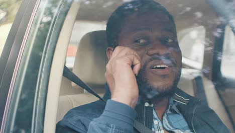 Handsome-Young-Entrepreneur-Traveling-on-a-Passenger-Seat-of-a-Car-Makes-a-Phone-Call,-Talks-with-Clients-or-Relatives.-Camera-Shot-from-Outside-the-Vehicle.