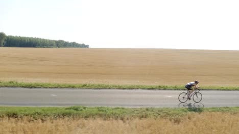 Drone-Schuss-des-Mannes-Fahrrad-zu-üben.-Luftaufnahme-des-Athleten-training-für-ein-Triatlon-Rennen,