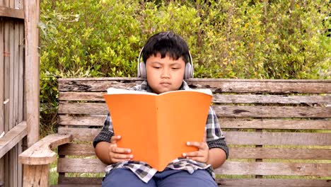 Süße-asiatische-Kinder-ein-Buch-lesen-und-hören-Sie-Musik-zu-Hause.-Bildungskonzept