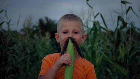 Un-muchacho-con-bigote-de-seda-del-maíz.-Boy-hacer-un-bigote-de-pelo-de-maíz