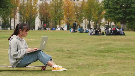 Asiáticas-chica-en-patineta-con-laptop-en-campus