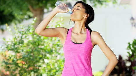 Porträt-ethnischen-weibliche-Trinkwasser-Fitness-Routine-im-freien