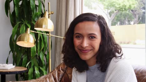 Mujer-de-raza-mixta-joven-sonriendo-a-la-cámara-en-una-tienda-de-café