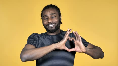 Handmade-Heart-by-Casual-African-Man-Isolated-on-Yellow-Background