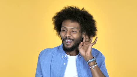 Afro-American-Man-Listening-Secret-Standing-on-Yellow-Background