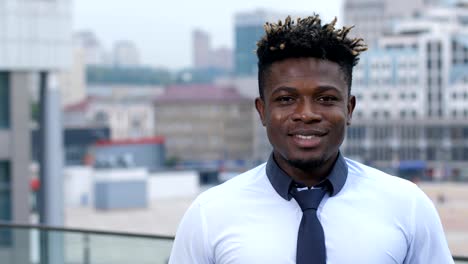 Portrait-of-smiling-businessman-standing-outdoors