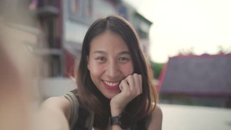 Fröhlich-schönen-jungen-asiatischen-Backpacker-Blogger-Frau-mit-Smartphone-unter-Selfie-unterwegs-in-Chinatown-in-Peking,-China.-Lebensstil-Rucksack-Tourist-Reisen-Urlaub-Konzept.-Point-Of-View.