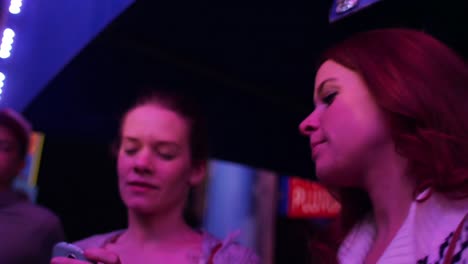 Two-friends-in-line-at-a-carnival-taking-pictures