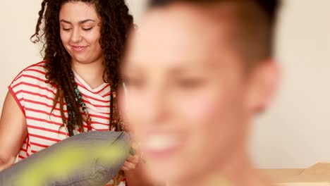 Smiling-lesbian-couple-unpacking-cardboard-box