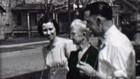 1939:-Family-together-front-yard-windy-day-neighborhood-city-home.