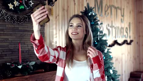 Woman-doing-selfie-against-Christmas-decor