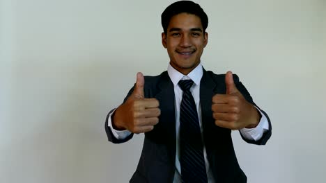 business,-people,-success,-happiness-and-cheerful-concept---smiling-young-man-startup-entrepreneur-businessman-wearing-gray-suit-giving-thumbs-up-with-white-background
