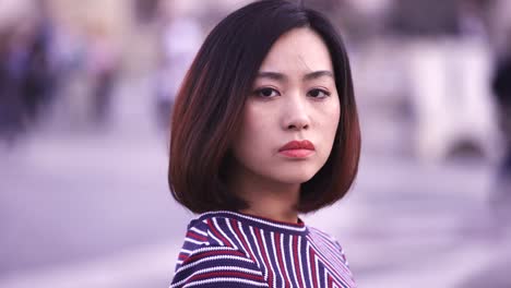 sad-and-serious-Chinese-woman-turns-her-head-and-looks-at-the-camera