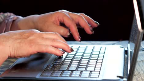 An-older-woman-checks-the-messages-on-social-networks-on-a-laptop-at-home.-She-sits-at-the-table