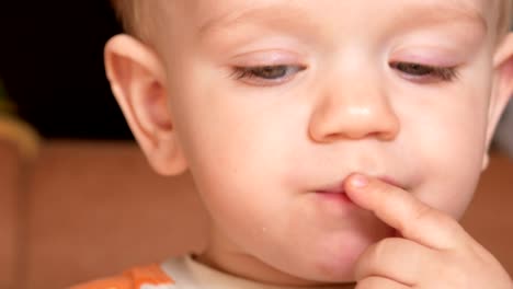 Cute-kid-two-years-of-eating-a-muffin-at-home.-Close-up