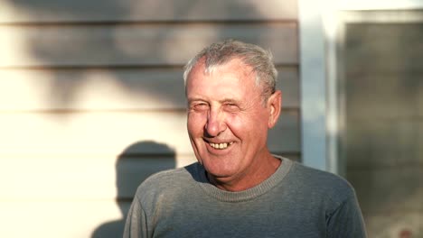 Close-up-of-smiling-old-man-face-standing-in-front-of-camera,-smiling,-laughing,-talking-outdoor-in-sunlight.-4K