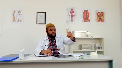 African-american-male-doctor-taking-selfies-and-showing-thumb-up