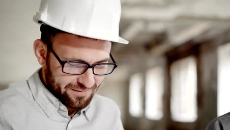 Porträt-eines-zufrieden-Geschäftsmann-in-einem-Helm-auf-dem-Kopf,-die-Fertigstellung-der-Baustelle-mit-einem-Vorarbeiter-diskutiert