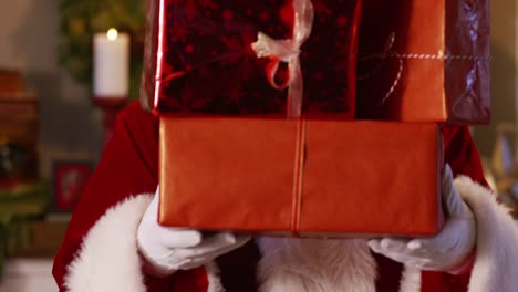 Santa-Claus-peeks-out-from-behind-stack-of-gifts