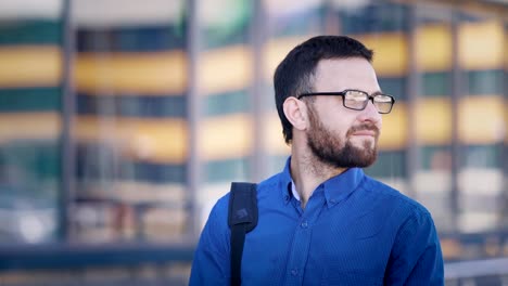 Dreamy-office-worker-in-street.-Pensive-smiling-male-employee-walking-in-the-street-at-office-building-and-looking-away