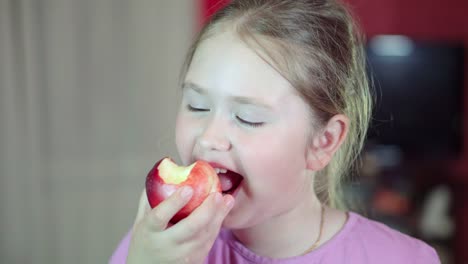 Caucasian-white-baby-eats-a-nectarine-and-smiling-at-the-camera.-4K