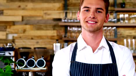 Portrait-of-male-waiter-standing-with-arms-crossed