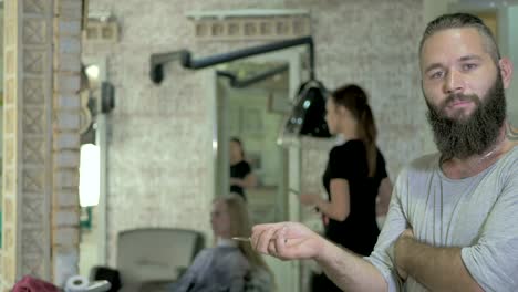 Portrait-of-bearded-hairdresser-in-barbershop