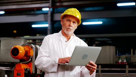 Engineer-using-laptop-in-bottle-factory