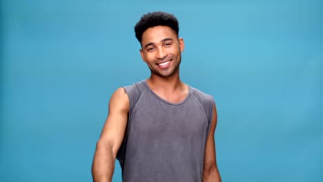 Young-smiling-african-man-showing-thumbs-up-over-blue-background.