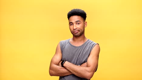 Young-serious-african-man-with-arms-crossed-over-yellow-background.
