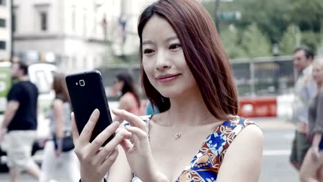 Handsome-Chinese-Woman-Texting-and-Talking-to-the-Phone-in-the-City.-Being-Happy,-Smiling-and-Having-Fun.