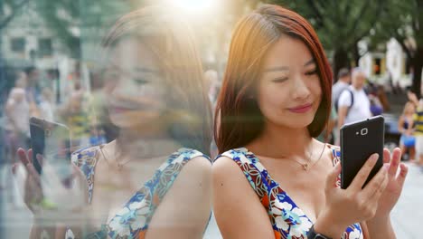 Attractive-Asian-Woman-Using-Phone-in-the-City.-Dark-Eyes-and-Dark-Hair.-Crowded-and-Urban-Background.